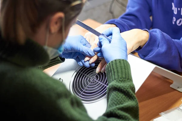 In the salon master of manicure nail extension treatment of the nail plate.