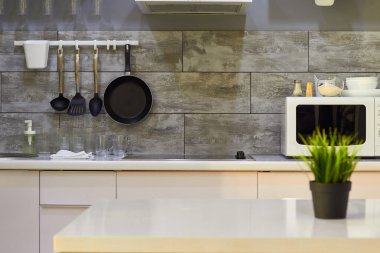 Yemek odasının fotoğrafı arka planda yeşil bir bitki bulunan bir masa, mikrodalga fırın..