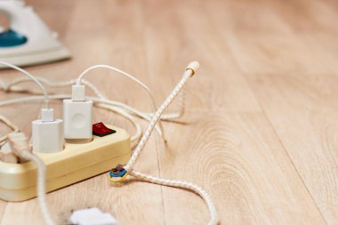 Fotoğraf, yerde yatan uzatma kablosunu geniş bir akım tüketimiyle gösteriyor. Yüksek enerji tüketimi kavramı.