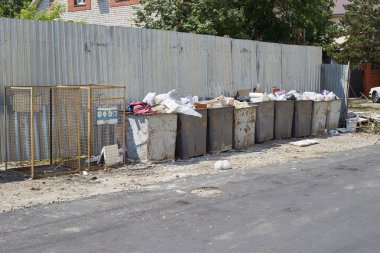 Çöp tenekeleri çit boyunca eski ve kirli.