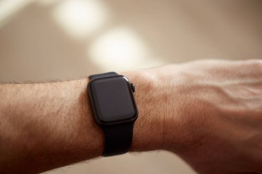 Bir adamın elindeki akıllı saat, siyah ekran, açık arkaplan