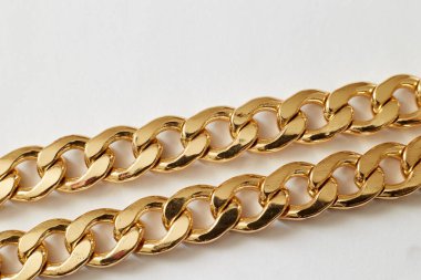 Beyaz arka planda altın zincir yakın plan, zenginlik lüksü