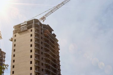 Şehir merkezinde, vinç yakınında penceresi olmayan yüksek bir konut inşaatı.