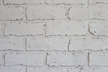 Duvarda beyaz tuğla şeklinde dekoratif alçı var..