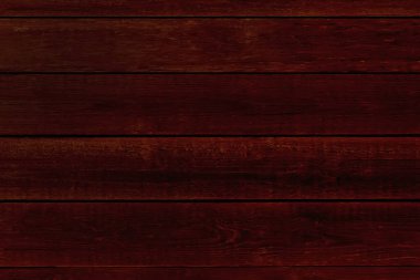 Pürüzsüz maun tahtaların üst görüntüsünden koyu arkaplan. Koyu kırmızı ahşap desen eşit aydınlatılmış.