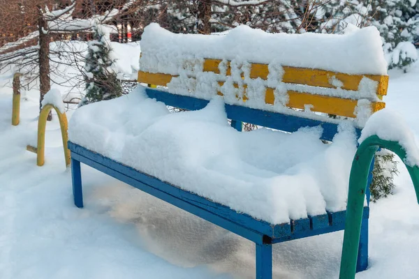 Żółto Niebieska Ławka Pokryta Grubą Warstwą Śniegu Parku — Zdjęcie stockowe