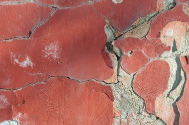Çatlak arka planı olan eski bir duvar. Duvarda çatlaklar var, kırmızı yakın plan.
