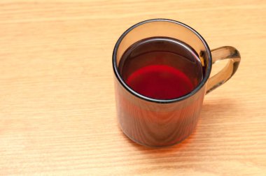 koyu şeffaf kupa ve koyu çay masanın üzerinde duruyor. Yakın plan yumuşak odak.