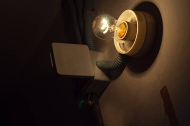 Parlayan parlak lamba ile eski karanlık bodrum koridoru duvarı