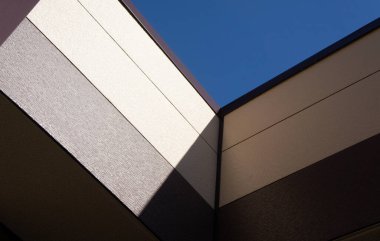 Binanın köşegenleri ve mavi gökyüzünün kırıntıları üzerinde ışık ve gölgenin geometrik soyutlaması