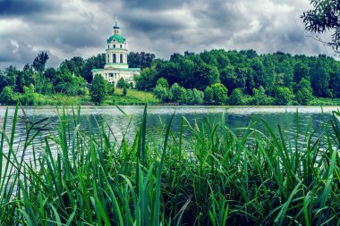 Bulutlu bir günde göl ve kilise çan kulesi
