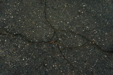 koyu arkaplan eski asfalt çatlakları küçük çok renkli çakıl ile kesişir