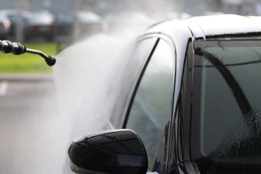 Açık havada siyah bir arabayı temas etmeden yıkamak..