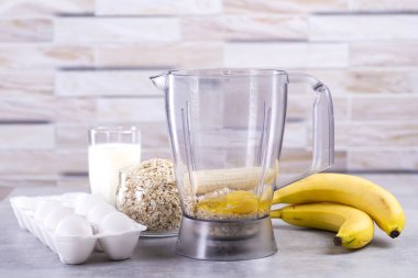 Muzlu yulaf gözlemesi. Aşama aşama aşama. İçindekiler üst görünüm. Muz, süt, yumurta, yulaf, tuz. Ahşap masa arka planı. Boşluğu kopyala.