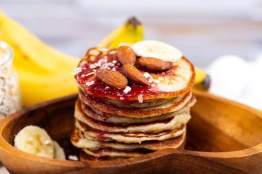 Ahşap tabakta reçelli ve bademli yulaf krepleri..