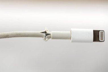 Işık arkaplanındaki bozuk akıllı telefon şarj kablosunu kapat.