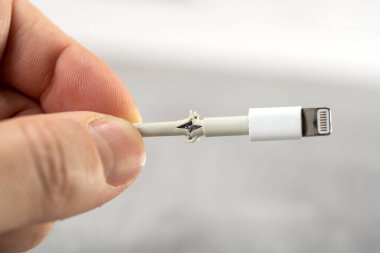 Işık arkaplanındaki bozuk akıllı telefon şarj kablosunu kapat.