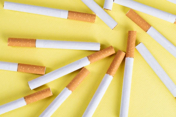 许多黄色背景的工业香烟 — 图库照片