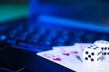 Çevrimiçi oyun platformu, kumarhane ve kumar işi. Dizüstü bilgisayardaki kartlar ve zarlar, mavi tonlu..