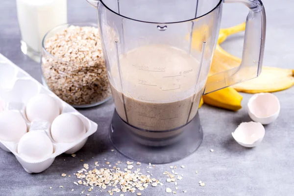 Oats and eggs in a blender. Oat pancakes with banana. Step by step cooking process. Bananas, milk, eggs, oats, salt.