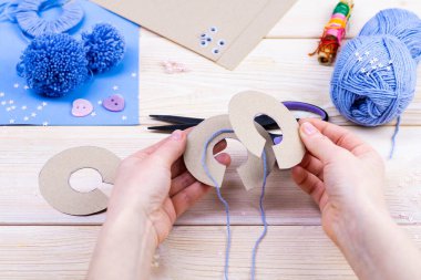 Paskalya dekoru için ponponlardan tavşan yapmayı. Çocuk sanat projesi. Diy konsepti. Eller ponpondan mavi bir Paskalya tavşanı yapar. Adım adım fotoğraf talimatı.