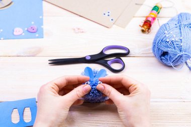 Paskalya dekoru için ponponlardan tavşan yapmayı. Çocuk sanat projesi. Diy konsepti. Eller ponpondan mavi bir Paskalya tavşanı yapar. Adım adım fotoğraf talimatı.