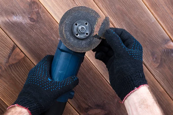 Tahta bir masada kırık bir bıçakla öğütücü. Elektrikli aletler kullanmanın tehlikesi.