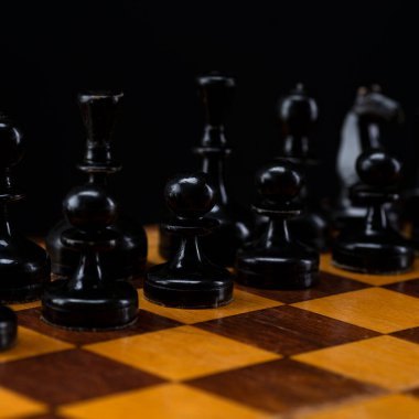 Satranç tahtasındaki siyah satranç taşları. Masada siyah piyon ordusu var..