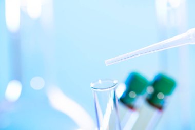 Kimyasal test tüpü ve pipeti mavi arkaplanı kapatın..