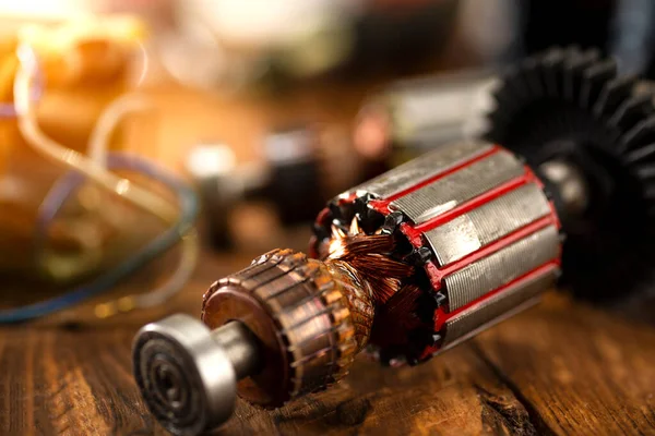 Power tool repair. Details of electrical appliance and repair tools on a wooden table in a repair shop.