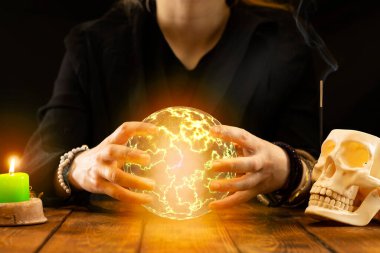 Falcı ya da falcı seans sırasında geleceği tahmin etmek için elinde bir ateş topu tutuyor. Psişik okumalar ve kehanet kavramı..