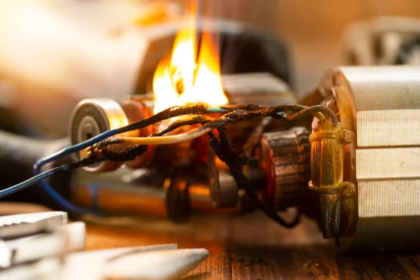 Burning wires on the details of an electrical appliance on a wooden table in a repair shop. Power tool repair.