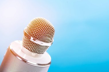 Mavi arka planda hoparlörlü karaoke için mikrofon