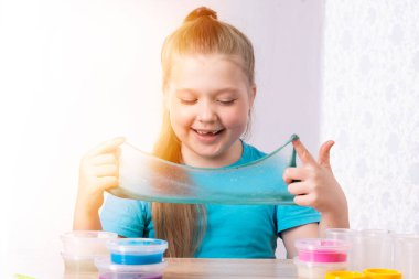 Sarışın bir çocuk bir sümükle oynuyor. Küçük güzel beyaz kız bir sürü sümükle oynuyor. Sümük Oyuncağı Oynat.