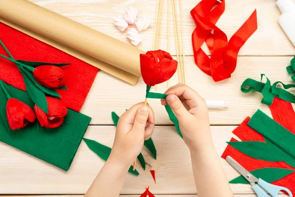 How to make a tulip flower out of paper and marshmallows at home. Marshmallow inside a red tulip bud. Hands make a red tulip. Step-by-step instruction. DIY children\'s art project.