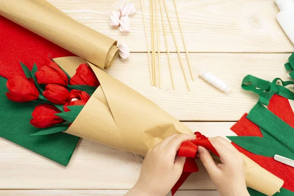 How to make a tulip flower out of paper and marshmallows at home. Marshmallow inside a red tulip bud. Hands make a red tulip. Step-by-step instruction. DIY children's art project.