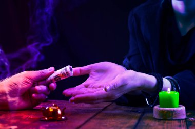 Müşteri para veriyor, bir boruya sarılmış bir falcıya ya da bir kahine, neon ışığa..