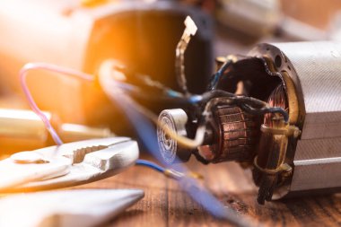 Elektrikli alet tamiri. Tamirhanenin ahşap masasındaki elektrikli aletlerin ve tamir aletlerinin detayları.