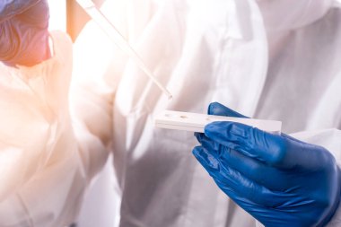 Su kalitesini kontrol ediyorum. Bilim adamı, suyun kalitesini belirlemek için test şeridine bir damla su damlatıyor..