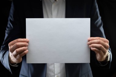 Önünde boş kağıtlar tutan bir iş adamı..