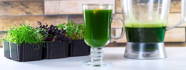 Jugo microverde en la mesa de la cocina. Micro greens en una licuadora. Haz un batido microverde en casa. Alimento sano y ecológico — Foto de Stock