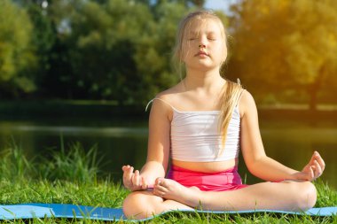 Parkta yoga, sağlık ve egzersiz konseptinde poz veren beyaz bir kız..