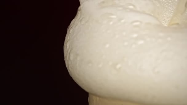 Slow motion beer foam spills over the edge of the beer glass — Stock Video