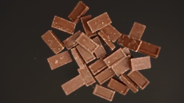 Медленное движение шоколадной плитки на черном фоне — стоковое видео