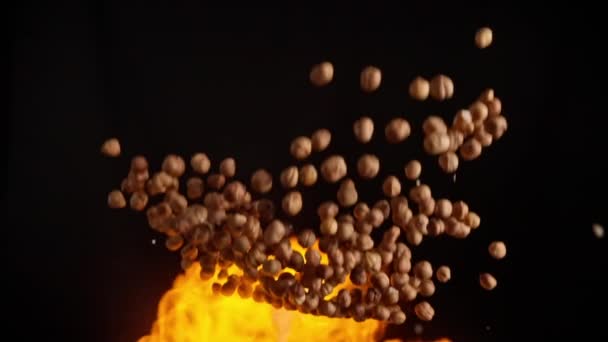 Explosão lenta de avelã voando em chamas — Vídeo de Stock