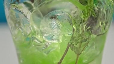 Yavaş çekim yeşil limonata, buzlu bardağa doldurulur.