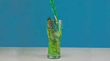 Yavaş çekim yeşil limonata, buzlu bardağa doldurulur.