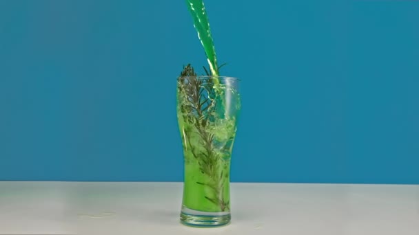 La limonade verte au mouvement lent est versée dans un verre avec de la glace en gros plan — Video