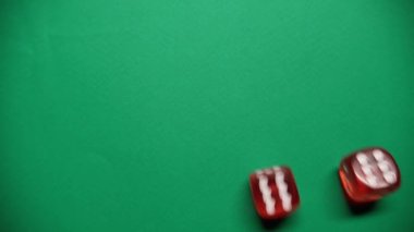 Kırmızı zar yeşil masaya düşüyor. Zarda 6 ve 5 numaralar görünüyor..