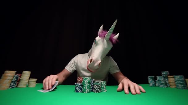 Tek boynuzlu at poker oynar, kartlarına bakar ve her şeyini ortaya koyar. — Stok video